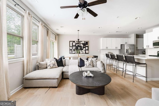 living area featuring plenty of natural light, light wood finished floors, and ceiling fan