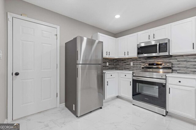 7074 Ravenwood Ln, Lithonia, GA 30038 - kitchen featuring light countertops, marble finish floor, stainless steel appliances, white cabinetry, and backsplash