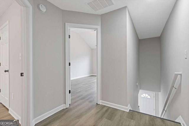 7074 Ravenwood Ln, Lithonia, GA 30038 - hall featuring baseboards, visible vents, wood finished floors, and an upstairs landing