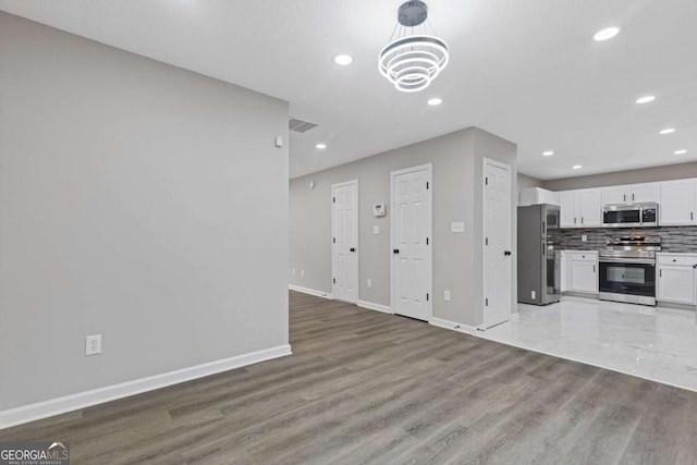 7074 Ravenwood Ln, Lithonia, GA 30038 - unfurnished living room with baseboards, recessed lighting, and a notable chandelier