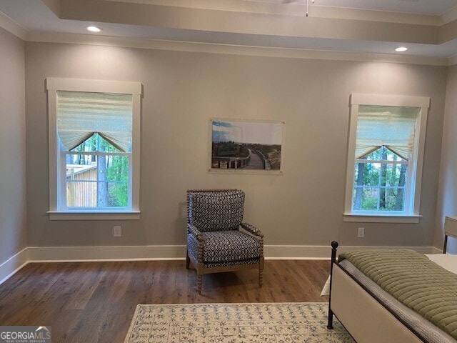 bedroom with baseboards, multiple windows, wood finished floors, and ornamental molding
