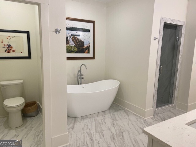 full bath with a freestanding bath, a shower stall, baseboards, toilet, and marble finish floor