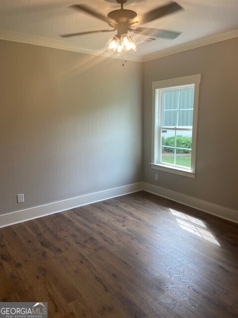 unfurnished room featuring dark wood-type flooring, ornamental molding, and ceiling fan