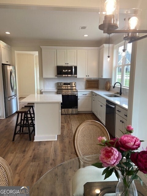 kitchen with visible vents, a sink, light countertops, white cabinets, and stainless steel appliances