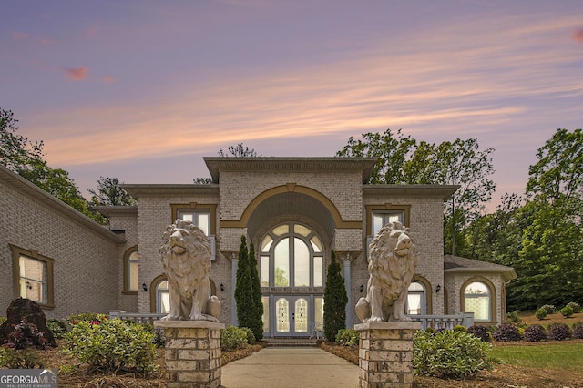 view of front of house featuring brick siding and french doors