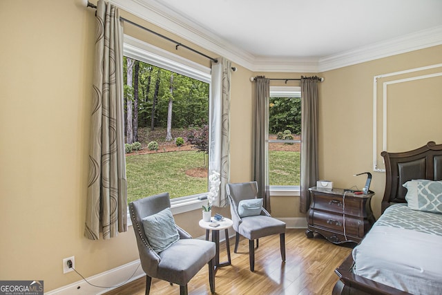 bedroom with baseboards, ornamental molding, and wood finished floors