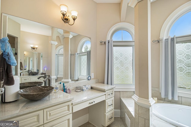 full bath with ornate columns, a bath, and vanity