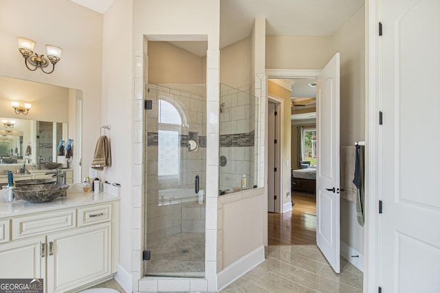 ensuite bathroom featuring vanity, baseboards, connected bathroom, and a stall shower