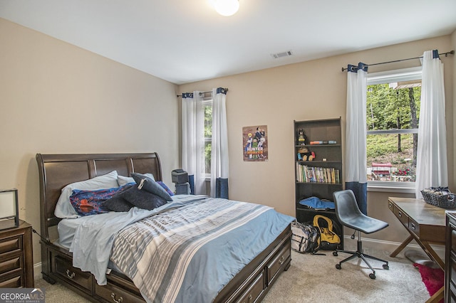 bedroom with baseboards, visible vents, and light carpet