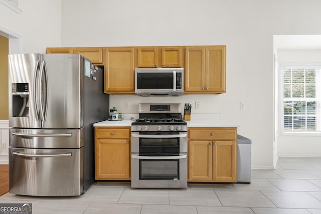 1395 Brisbane Dr, Dacula, GA 30019 - kitchen featuring appliances with stainless steel finishes, light countertops, baseboards, and light tile patterned floors
