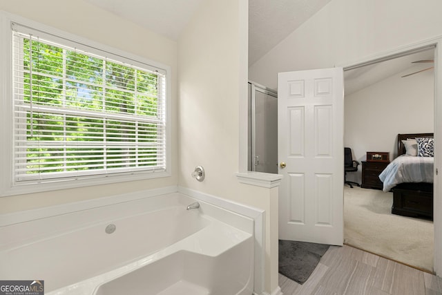 1395 Brisbane Dr, Dacula, GA 30019 - ensuite bathroom featuring vaulted ceiling, plenty of natural light, a shower stall, and a bath