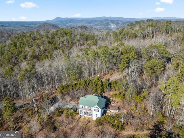 birds eye view of property featuring a wooded view and a mountain view