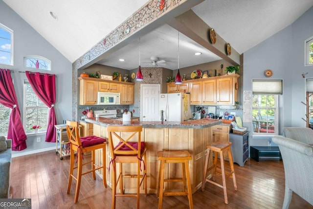 kitchen with light brown cabinetry, high vaulted ceiling, hardwood / wood-style flooring, and white appliances