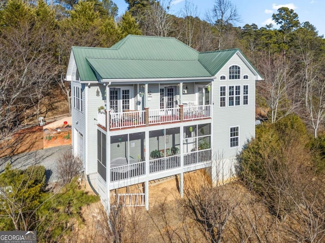 rear view of property with a sunroom and metal roof