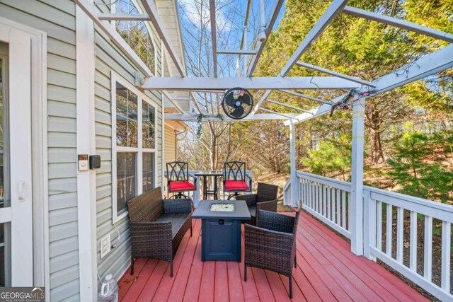 wooden deck featuring an outdoor living space with a fire pit and a pergola
