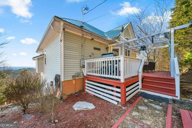 view of side of property with metal roof and a deck