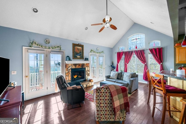 living area featuring visible vents, a stone fireplace, dark wood-style floors, high vaulted ceiling, and a ceiling fan