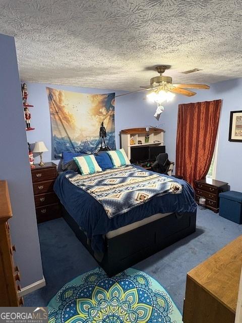 carpeted bedroom featuring a textured ceiling and a ceiling fan