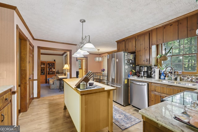 3876 Winners Ct, Marietta, GA 30062 - kitchen featuring appliances with stainless steel finishes, ornamental molding, a kitchen island, light wood finished floors, and decorative light fixtures