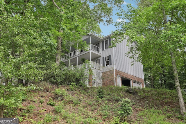 3876 Winners Ct, Marietta, GA 30062 - back of house featuring a balcony, an attached garage, and brick siding
