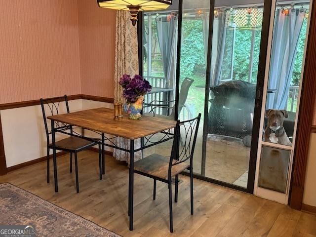 dining area with light wood finished floors, healthy amount of natural light, and baseboards