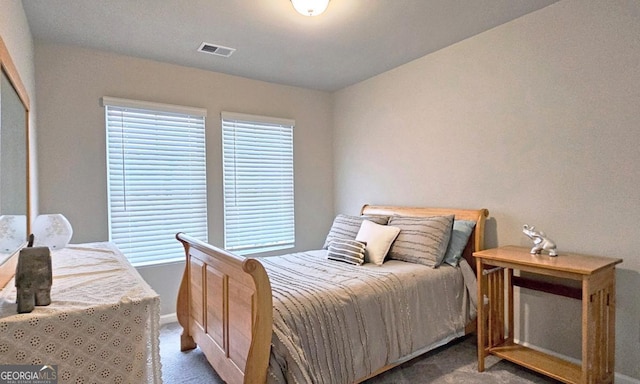 carpeted bedroom featuring baseboards and visible vents