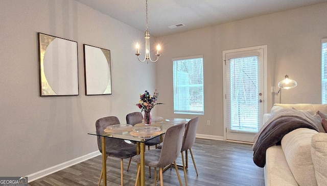 dining area featuring dark wood-style flooring, a chandelier, baseboards, and visible vents