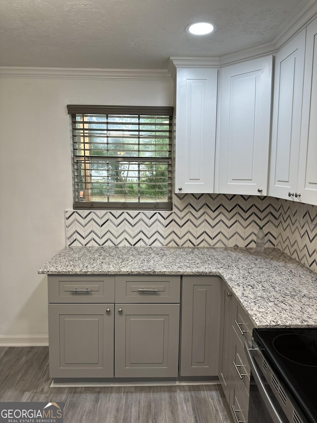 kitchen featuring crown molding, dark wood-style flooring, baseboards, tasteful backsplash, and gray cabinetry