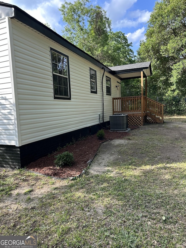 view of property exterior with crawl space, central air condition unit, a yard, and a wooden deck