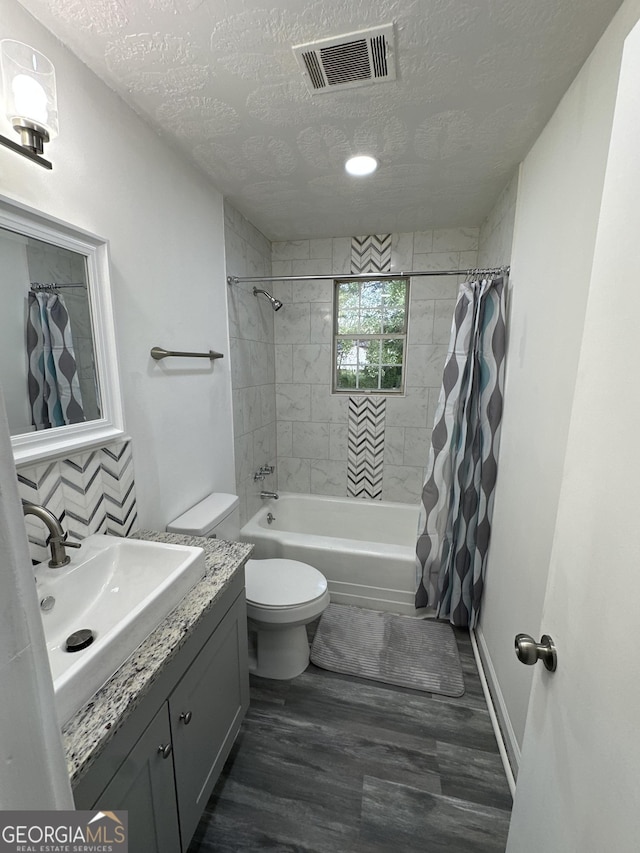bathroom featuring shower / tub combo with curtain, toilet, a textured ceiling, wood finished floors, and visible vents