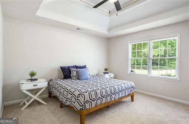 bedroom featuring carpet flooring, a tray ceiling, and baseboards