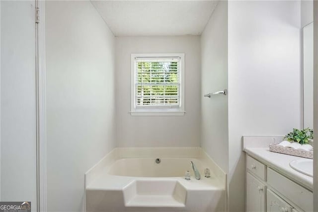 bathroom featuring a garden tub and vanity