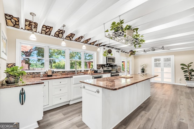 701 Mask Rd, Brooks, GA 30205 - kitchen with white cabinets, appliances with stainless steel finishes, dark stone countertops, a center island, and beamed ceiling