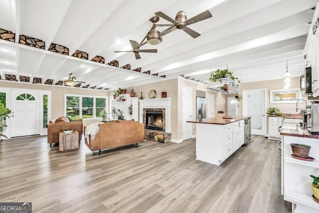 701 Mask Rd, Brooks, GA 30205 - living area featuring light wood-type flooring, ceiling fan, a fireplace, and beamed ceiling