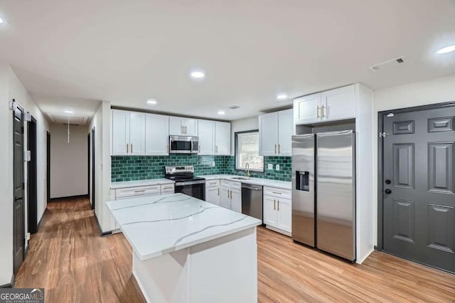 2091 Parker Ranch Rd SE, Atlanta, GA 30316 - kitchen featuring tasteful backsplash, light stone counters, a sink, light wood-style flooring, and stainless steel appliances