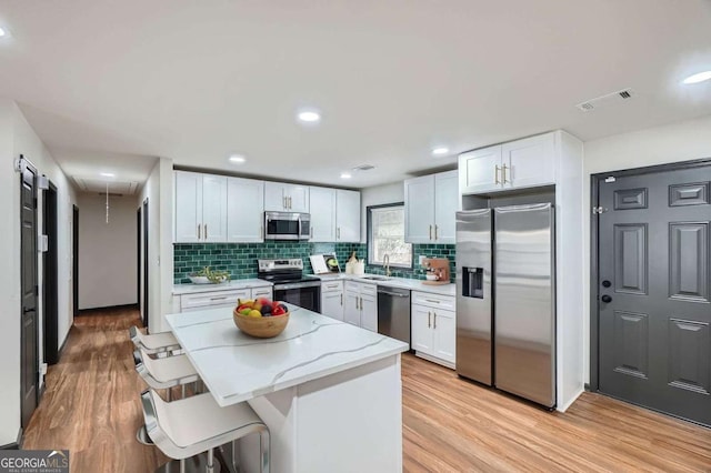 2091 Parker Ranch Rd SE, Atlanta, GA 30316 - kitchen with decorative backsplash, light stone countertops, a sink, stainless steel appliances, and light wood-style flooring