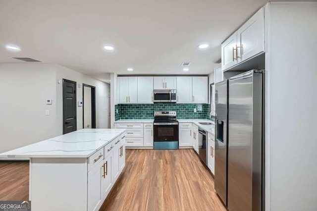2091 Parker Ranch Rd SE, Atlanta, GA 30316 - kitchen with a sink, light wood-style flooring, appliances with stainless steel finishes, and white cabinets