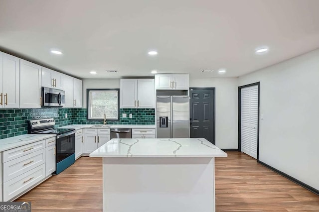2091 Parker Ranch Rd SE, Atlanta, GA 30316 - kitchen featuring a sink, light wood-style flooring, stainless steel appliances, tasteful backsplash, and a kitchen island