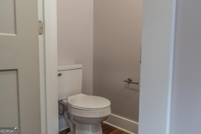 bathroom featuring wood finished floors and toilet