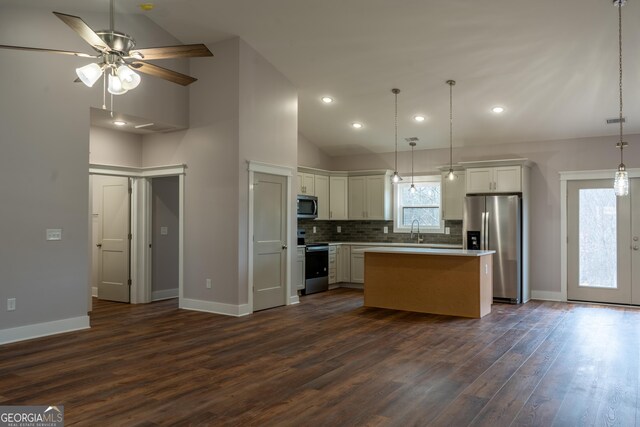 kitchen featuring baseboards, appliances with stainless steel finishes, a sink, and dark wood finished floors