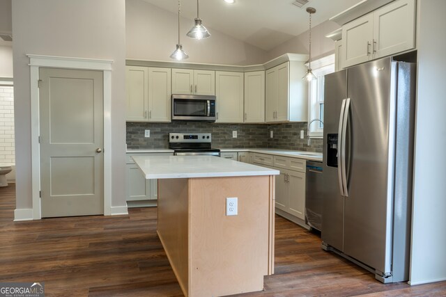 kitchen featuring decorative backsplash, dark wood-style flooring, lofted ceiling, light countertops, and appliances with stainless steel finishes