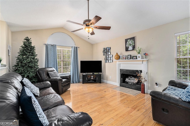221 Hunters Xing SE, Calhoun, GA 30701 - living room with ceiling fan, a fireplace with flush hearth, baseboards, lofted ceiling, and light wood-style floors