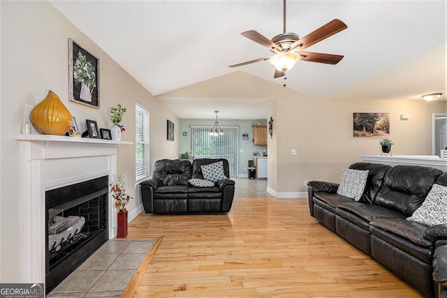 221 Hunters Xing SE, Calhoun, GA 30701 - living room featuring light wood-type flooring, a ceiling fan, lofted ceiling, a fireplace with flush hearth, and a chandelier