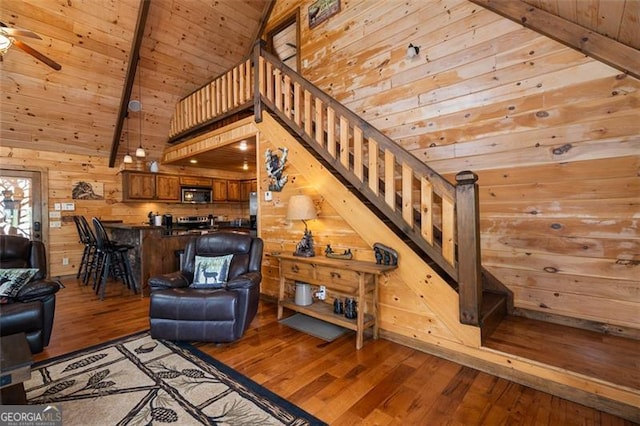 675 Green Ridge Rd, Blue Ridge, GA 30513 - living room featuring stairs, beam ceiling, light wood-style floors, ceiling fan, and wooden walls