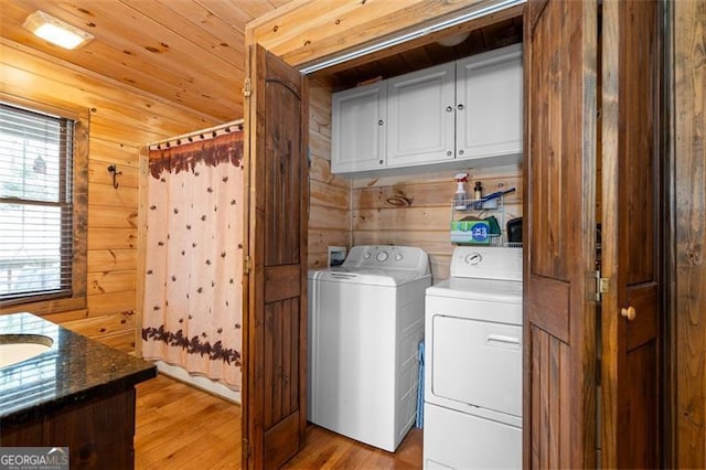 675 Green Ridge Rd, Blue Ridge, GA 30513 - laundry area with washing machine and clothes dryer, wood walls, light wood-style flooring, and cabinet space