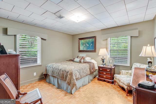 bedroom featuring baseboards and visible vents