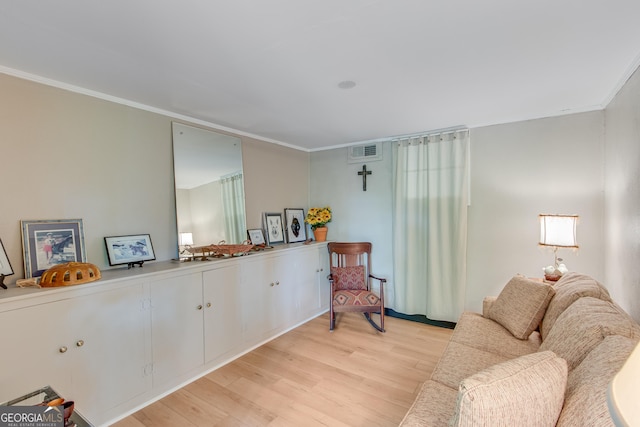 sitting room featuring visible vents, ornamental molding, and light wood finished floors