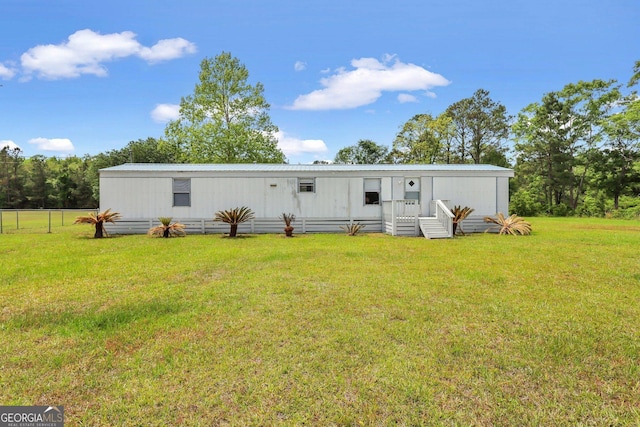 view of front of home with fence, metal roof, and a front yard