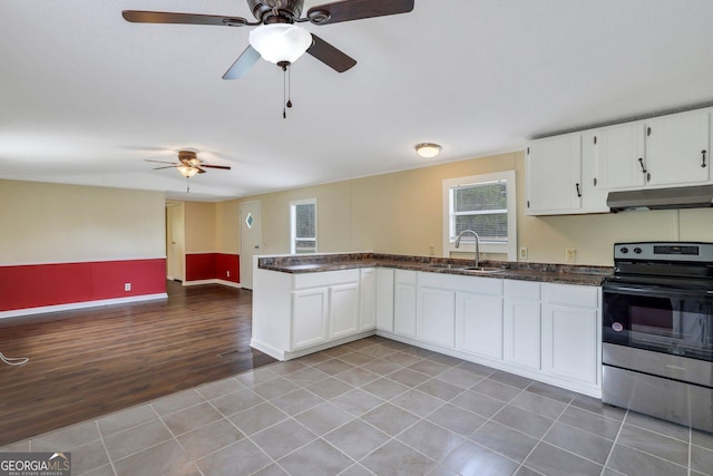 kitchen with stainless steel electric range oven, white cabinetry, under cabinet range hood, and a sink