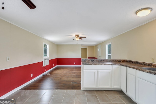 kitchen with a ceiling fan, dark countertops, white cabinetry, and light wood-style flooring